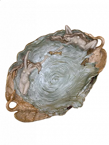 Oval ceramic bas-relief with two mermaids, fish and two swan handles, early 20th century