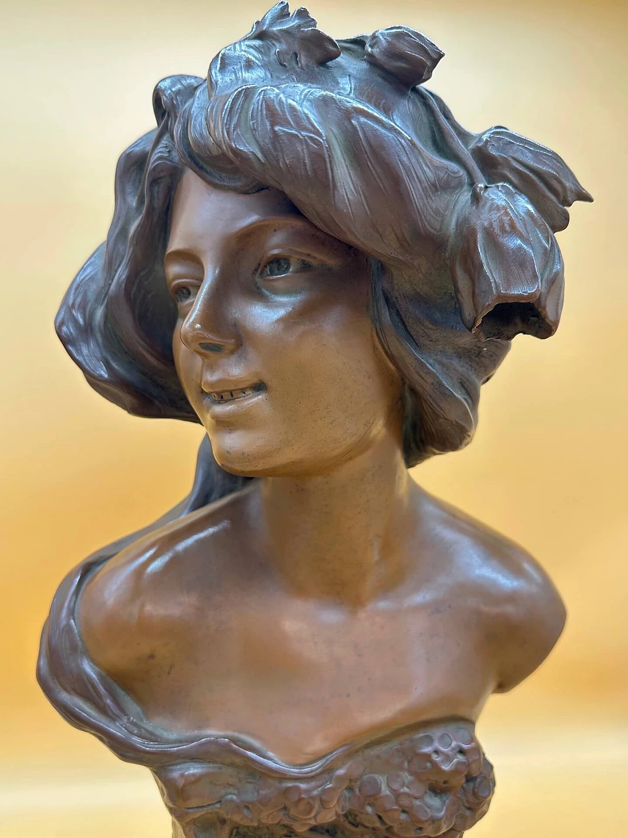 Bronze-plated terracotta bust of a young girl with decorations and flowers, early 20th century 1