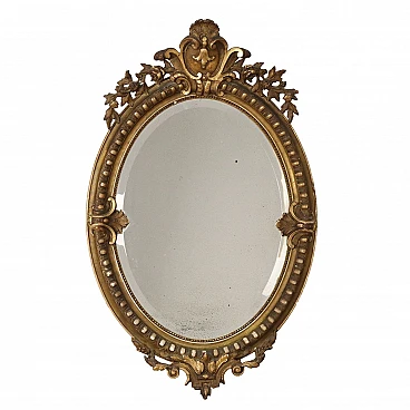 Specchio ovale con cornice dorata e motivi a ricciolo e fogliacei